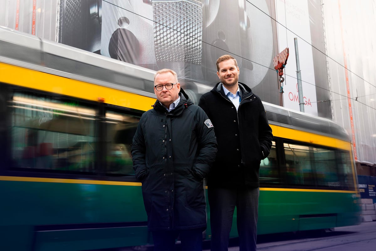 Ilmarisen Ville Laurila ja ISS:n Kimmo Kaunisvaara seisomassa kadulla vierekkäin, taustalla raitiovaunu ajamassa ohi.