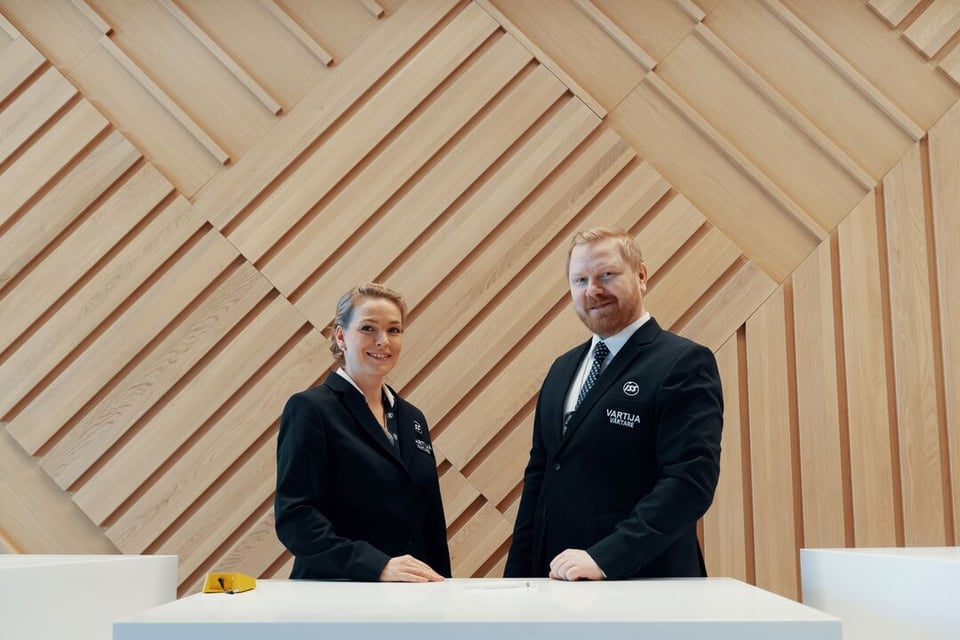Kaksi ISS:n vartijaa aulan vastaanottotiskin takana.