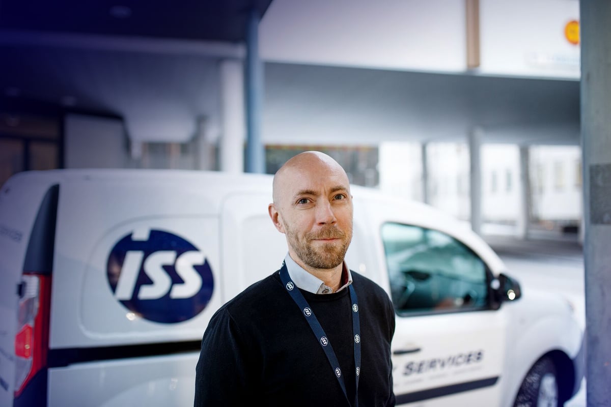 ISS:n työntekijä, taustalla ISS:n valkoinen palveluauto.