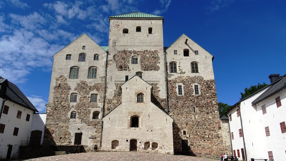 Turun linna aurinkoisena kesäpäivänä, taustalla sininen taivas.